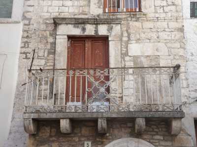 Al portale ad arco segue al secondo livello un balconcino dalle ringhiere in ferro ed una finestra frontonata...